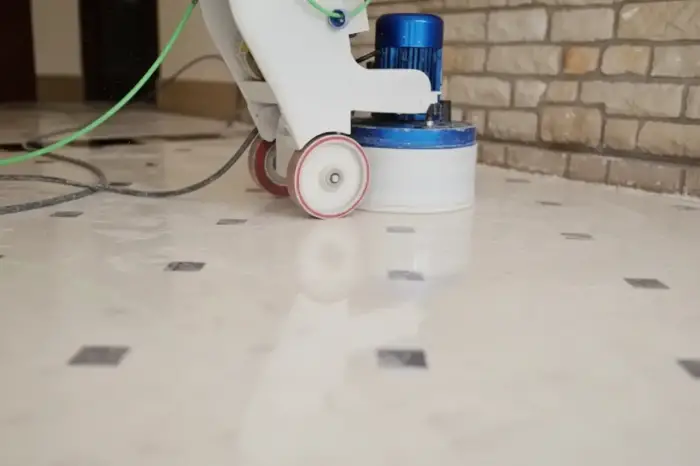 Ponceuse italienne préparant un sol en marbre blanc pour un traitement hydrofuge